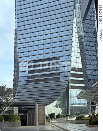 Modern glass skyscraper with unique architectural design and reflective facade Modern glass skyscraper with unique architectural design and reflective facade 140197455