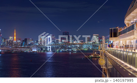 Tokyo, Japan - Oct 2 2024, panoramic aerial view of Tokyo Bay cityscape with skyscrapers and Rainbow Bridge, at night with illumination, from a upper deck of cruise ship MSC Bellissima, Tokyo, Japan 140197995