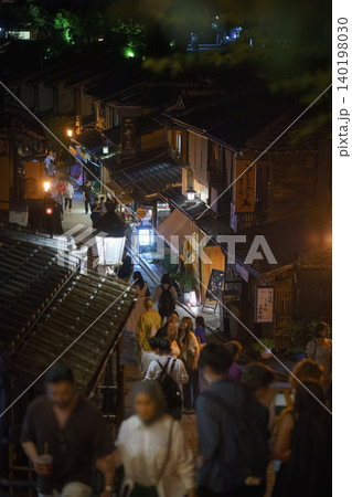 Kyoto, Japan - Sep 23 2024, vertical view of the ancient street on the mountainside in Gion district, at night, with many people strolling, Kyoto, Japan 140198030