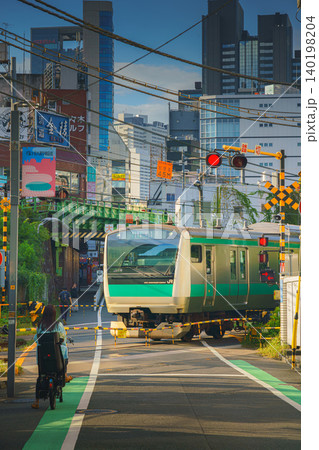 Tokyo, Japan - Oct 15 2024, vertical view of railway crossing with several intersecting railway tracks with passing trains near Yoyogi station, people walking along street, at daytime,Tokyo, Japan Tokyo, Japan - Oct 15 2024, vertical view of railway crossing with several intersecting railway tracks with passing trains near Yoyogi station, people walking along street, at daytime,Tokyo, Japan 140198204