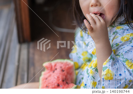 縁側でスイカを食べる少女 140198744