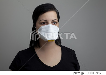 Woman wearing a white N95 mask 140199478
