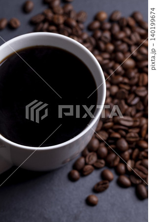 Roasted coffee beans and cup of coffee on granite background 140199674