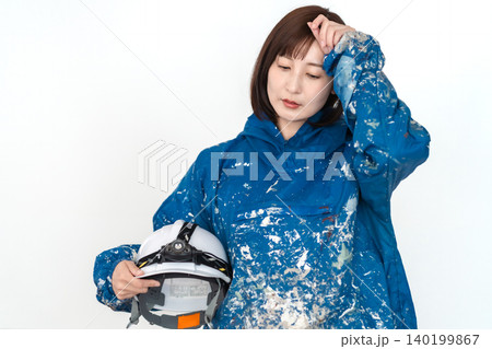 仕事に悩み疲れた表情を見せる青い作業着姿の女性作業員 建設建築イメージ 白背景 140199867