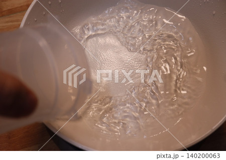 Pouring Water into a Pan Pouring Water into a Pan 140200063