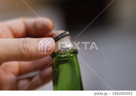 Hand Opening Green Bottle Cap Close-Up Hand Opening Green Bottle Cap Close-Up 140200301
