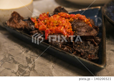 Balado Dendeng Renyah Padang, an Indonesian crispy beef dish coated with spicy balado chili seasoning, known for its bold and savory flavor. Balado Dendeng Renyah Padang, an Indonesian crispy beef dish coated with spicy balado chili seasoning, known for its bold and savory flavor. 140200321