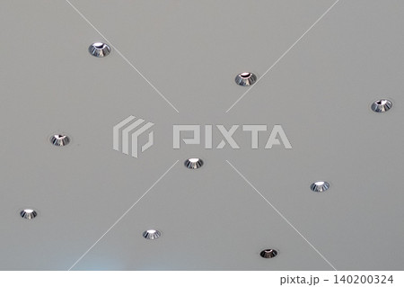 Group of recessed downlights installed on a gypsum board ceiling with a grid system, creating clean and uniform architectural lighting. 140200324