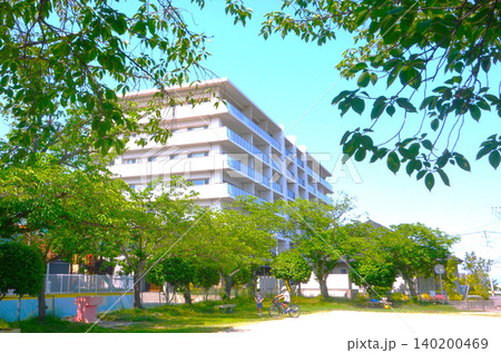 春の新緑の公園と白い中型マンション 140200469