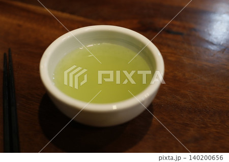 Matcha Tea in White Bowl on Wooden Table 140200656