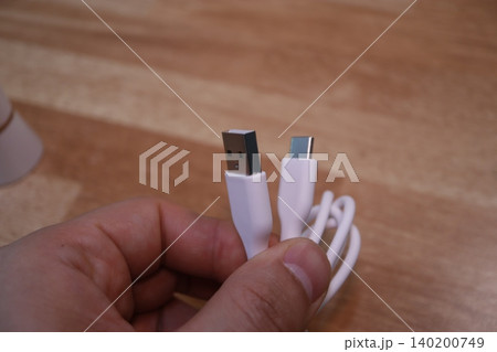 Hand Holding USB and USB-C Cables Close-Up Hand Holding USB and USB-C Cables Close-Up 140200749