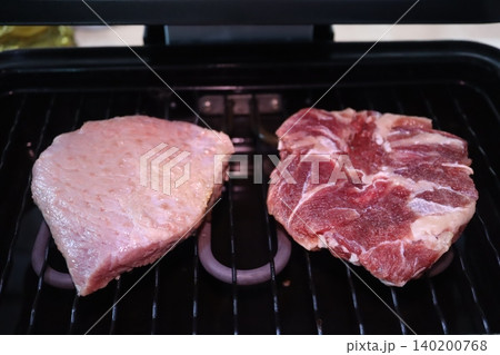 Two Raw Meat Steaks on Electric Grill Two Raw Meat Steaks on Electric Grill 140200768