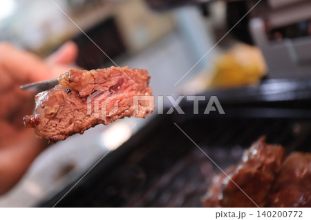 Grilled Steak Slice on Tongs Grilled Steak Slice on Tongs 140200772