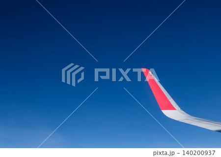 red winglet in graduated dark blue sky red winglet in graduated dark blue sky 140200937