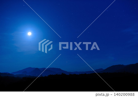 moonlight in the blue clear sky with a silhouette foreground of a forest and hill moonlight in the blue clear sky with a silhouette foreground of a forest and hill 140200988