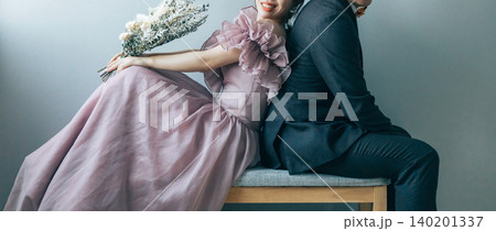 背中合わせで椅子に座って前撮り,ウェディングフォトを撮る新郎新婦 140201337