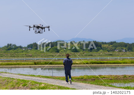 ドローンによる水田への除草剤散布作業とドローンオペレーター ドローンによる水田への除草剤散布作業とドローンオペレーター 140202175