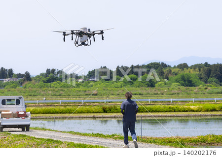ドローンによる水田への除草剤散布作業とドローンオペレーター ドローンによる水田への除草剤散布作業とドローンオペレーター 140202176