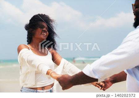 Joyful Black man and woman having fun during tropical summer holiday Joyful Black man and woman having fun during tropical summer holiday 140202372