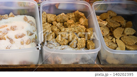 Traditional Chinese peanut candy with sesame coconut and almond cookies inside plastic boxes at local street food bakery shop counter display in Macau Traditional Chinese peanut candy with sesame coconut and almond cookies inside plastic boxes at local street food bakery shop counter display in Macau 140202395