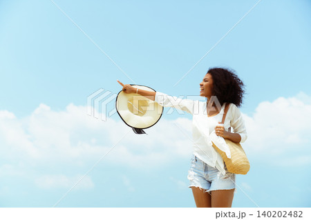 Happy young black woman stretching arms on sunny beach Happy young black woman stretching arms on sunny beach 140202482