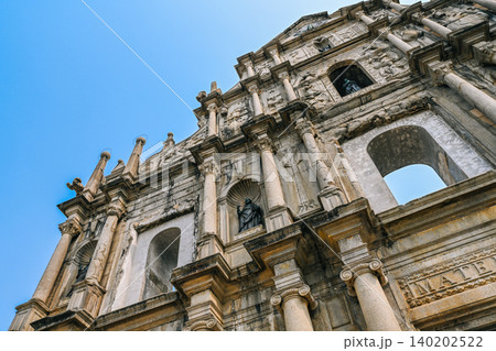 Bottom view of ancient unesco ruins of st paul mater dei church stone facade famous historical landmark and monument in Macau city China Bottom view of ancient unesco ruins of st paul mater dei church stone facade famous historical landmark and monument in Macau city China 140202522