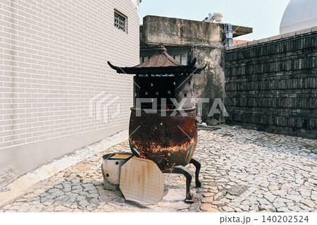 Ancient traditional bronze incense burner cauldron at chinese folk na tcha temple historic asian cultural landmark and tourist attraction in Macau China Ancient traditional bronze incense burner cauldron at chinese folk na tcha temple historic asian cultural landmark and tourist attraction in Macau China 140202524