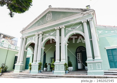 Beautiful green facade of historic unesco Dom Pedro V Theatre building with neoclassical architecture columns during summer day in Macau landmarks Beautiful green facade of historic unesco Dom Pedro V Theatre building with neoclassical architecture columns during summer day in Macau landmarks 140202545