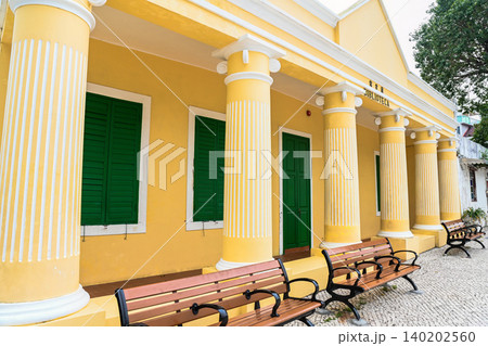 Side angle view of yellow Portuguese colonial architecture facade of historic Coloane Library built in 1911 in Macau China Side angle view of yellow Portuguese colonial architecture facade of historic Coloane Library built in 1911 in Macau China 140202560