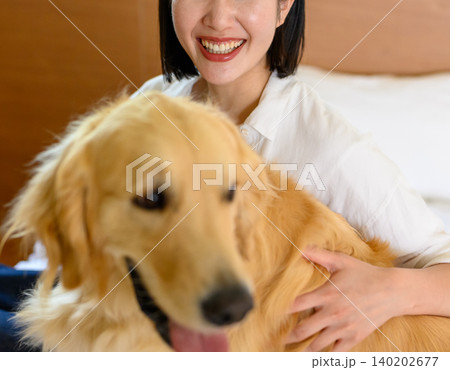 犬を抱きしめる笑顔の女性 犬を抱きしめる笑顔の女性 140202677