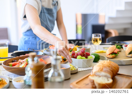食卓に並ぶ料理と女性の手 食卓に並ぶ料理と女性の手 140202761