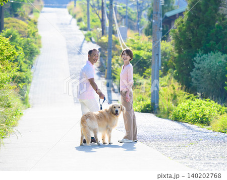 犬と坂道を散歩するカップル 140202768