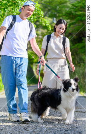 犬と散歩する若いカップル 犬と散歩する若いカップル 140202940