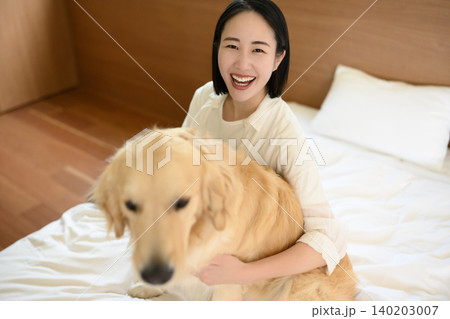 愛犬を抱きしめる笑顔の女性 140203007