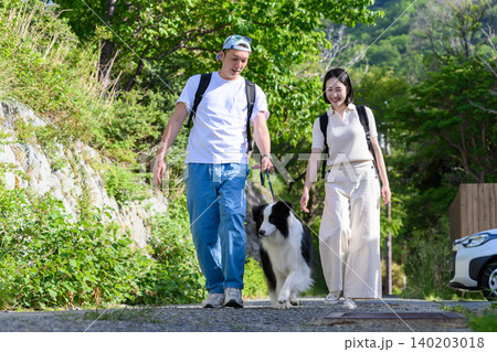 犬と散歩する若いカップル 犬と散歩する若いカップル 140203018