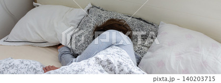A middle-aged woman is sleeping soundly in her bed, wearing a sleep mask. She is surrounded by soft pillows and a warm blanket, taking a break from her daily routine, banner A middle-aged woman is sleeping soundly in her bed, wearing a sleep mask. She is surrounded by soft pillows and a warm blanket, taking a break from her daily routine, banner 140203715