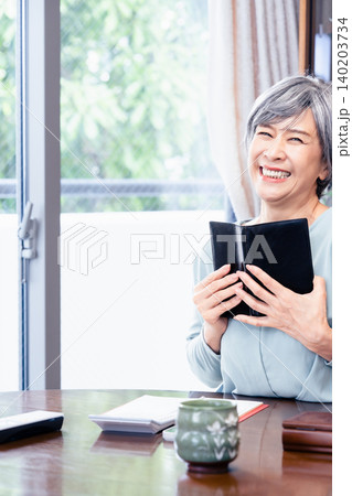 手帳を手にするシニア女性 手帳を手にするシニア女性 140203734