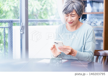 スマホを操作するシニア女性 スマホを操作するシニア女性 140203795