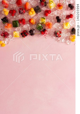 Pink background with ice cubes with frozen berries and fruits and mint Pink background with ice cubes with frozen berries and fruits and mint 140203994