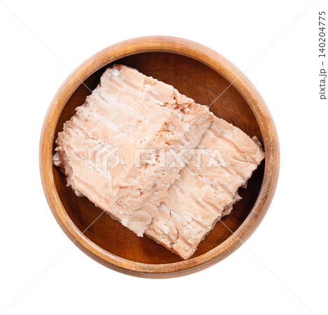 Pink salmon fillet pieces in a  wooden bowl. Wild-caught, canned Pink salmon, Oncorhynchus gorbuscha, with pale pink flesh, low oil content, mild flavour, and firm texture. Isolated from above. Photo 140204775