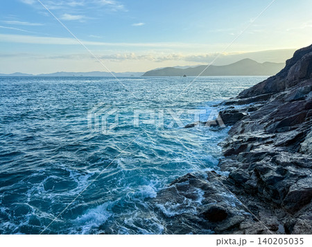 朝の磯に打ち寄せる波と青い海の海岸風景 朝の磯に打ち寄せる波と青い海の海岸風景 140205035