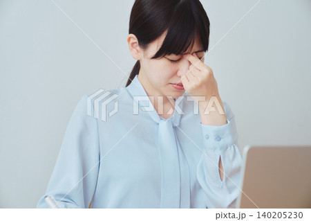 パソコン作業による眼精疲労に悩む女性 パソコン作業による眼精疲労に悩む女性 140205230