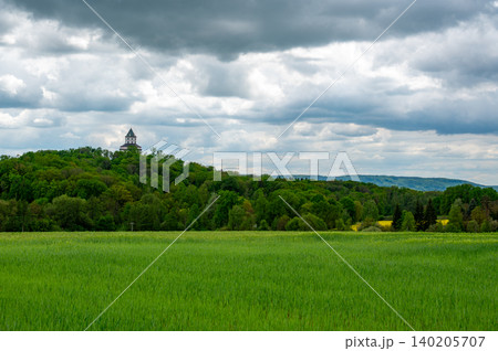 Panoramic view of Cesky Raj landscape in the Czech Republic with Humprecht Castle tower rising above meadows, forests and fields under a dramatic sky before spring rain. Panoramic view of Cesky Raj landscape in the Czech Republic with Humprecht Castle tower rising above meadows, forests and fields under a dramatic sky before spring rain. 140205707