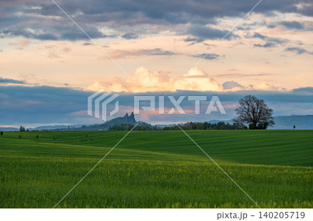 Panoramic view of Cesky Raj in Czech Republic with Trosky Castle ruins on twin basalt rocks. Sunset lights the clouds orange, a popular landmark above rolling countryside. Panoramic view of Cesky Raj in Czech Republic with Trosky Castle ruins on twin basalt rocks. Sunset lights the clouds orange, a popular landmark above rolling countryside. 140205719