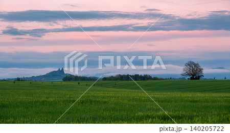 Panoramic view of Cesky Raj in Czech Republic with Trosky Castle ruins on twin basalt rocks. Sunset lights the clouds orange, a popular landmark above rolling countryside. Panoramic view of Cesky Raj in Czech Republic with Trosky Castle ruins on twin basalt rocks. Sunset lights the clouds orange, a popular landmark above rolling countryside. 140205722