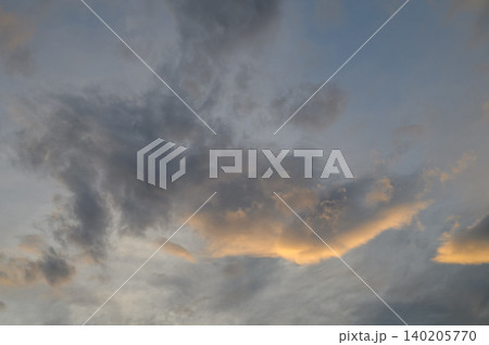 Overcast Evening Sky with Clouds of Varying Density Lit by Setting Sun, Golden and Orange Hues 140205770