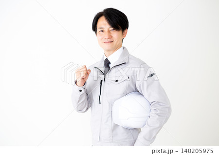 ガッツポーズするヘルメットを持ったグレーの作業着のミドル男性ビジネスマン白バック ガッツポーズするヘルメットを持ったグレーの作業着のミドル男性ビジネスマン白バック 140205975
