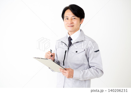 書類のバインダーを持つグレーの作業着のミドル男性ビジネスマン白バック 140206231