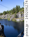 Ruskeala, Russia - July 10, 2021: A man hangs on a bungee above the lake of the Marble Canyon in Ruskeale in Karelia in Russia 140206274