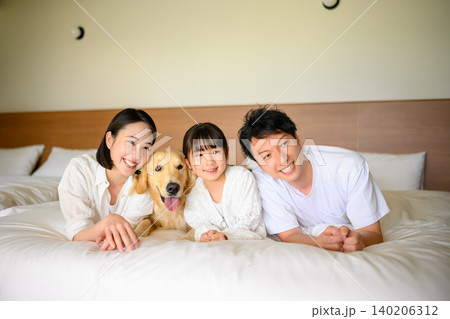 ベッドで寛ぐ家族と犬 ベッドで寛ぐ家族と犬 140206312